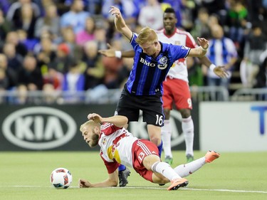 New York Red Bulls forward Mike Grella falls was he battles for the ball against Montreal Impact defender Calum Mallace during the second half of the Impact's home opening match at the Olympic Stadium in Montreal on Saturday, March 12, 2016.