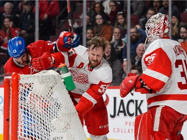 MONTREAL, QC - MARCH 29:  Mike Brown #13 of the Montreal Canadiens and Niklas Kronwall #55 of the Detroit Red Wings swing at each other near Red Wings goaltender Jimmy Howard #35 during the NHL game at the Bell Centre on March 29, 2016 in Montreal, Quebec, Canada.
