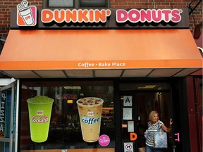 A woman walks out of a Dunkin' Donuts on July 25, 2013 in New York City.