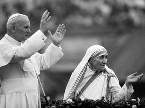 This file photo taken on February 3, 1986 shows Mother Teresa and Pope John Paul II waving to well-wishers, at the Nirmal Hriday Home, in Calcutta.