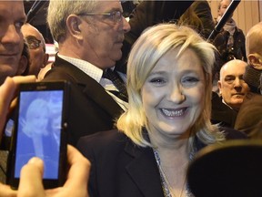French far right Front National (FN) party's president Marine Le Pen (C) poses for a picture as she meets farmers during her visit at the Salon de l'Agriculture (Agriculture Fair), in Paris, on March 1, 2016.