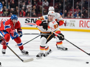 Sam Bennett of the Calgary Flames plays the puck past Paul Byron at the Bell Centre on Sundaym March 20, 2016, in Montreal.