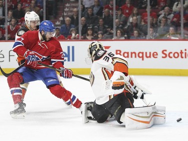 The puck trickles past Anaheim Ducks goalie John Gibson as Alex Galchenyuk crashes the net pursued by Jacob Silfverberg during first-period action in Montreal Tuesday March 22, 2016.