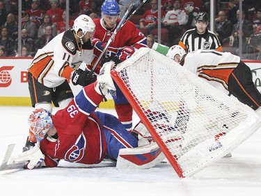 Goalie Mike Condon keeps an eye on the play as he holds up the net, which was knocked over by Anaheim Ducks' Corey Perry, right, while Habs' Alexie Emelin and Ducks' Brandon Pirri compete for position during second-period action in Montreal Tuesday, March 22, 2016.
