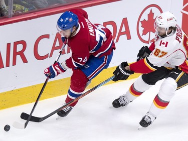 Montreal Canadiens defenceman Alexei Emelin handles the puck away from Calgary Flames' Michael Frolik during second-period action Sunday, March 20, 2016. in Montreal. THE CANADIAN PRESS/Paul Chiasson