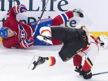 Montreal Canadiens' Alexei Emelin, left, and Calgary Flames' Michael Frolik fall to the ice after colliding during first- period - action Sunday, March 20, 2016, in Montreal.