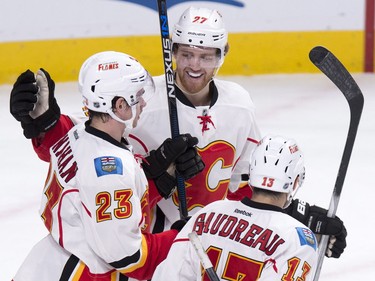 Calgary Flames' Sean Monahan is congratulated by teammates Dougie Hamilton, centre, and Johnny Gaudreau, right, after scoring on Mike Condon during second- period action Sunday, March 20, 201 in Montreal.