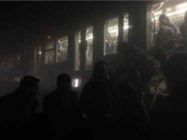 In this photo provided by Evan Lamos passengers clamber from a metro carriage after explosions in Brussels Tuesday, March 22, 2016.
