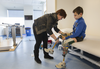 Alla Nyzhnykovska helps her 11-year-old son, Mykola Nyzhnykovskyi, put on a prosthetic leg prior to a session where he walked on them with a physiotherapist at Shriners Hospitals for Children in Montreal Tuesday, March 15, 2016. Mykola lost his legs and an arm in East Ukraine and sustained other serious injuries from an exploding grenade that killed his younger brother.