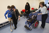 Alla Nyzhnykovska helps her son Mykola Nyzhnykovskyi towards a a training area where he was to start a session on his prosthetic legs with physiotherapist Rochelle Rein (right) at Shriners Hospitals for Children in Montreal Tuesday, March 15, 2016. Mykola lost his legs and an arm in East Ukraine and sustained other serious injuries from an exploding grenade that killed his younger brother. Behind is Lesia Prystupa, an interpreter and aid to  Mykola and his mother.