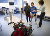 Mykola Nyzhnykovskyi is guided to his wheelchair by physiotherapist Rochelle Rein (left) and his mother Alla Nyzhnykovska at the end of a physio session at Shriners Hospitals for Children in Montreal Tuesday, March 15, 2016. Mykola lost his legs and an arm in East Ukraine and sustained other serious injuries from an exploding grenade that killed his younger brother.