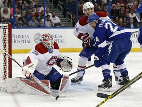 Montreal Canadiens goalie Mike Condon knocks a rebound away from Tampa Bay Lightning's Ryan Callahan, who is defended by Alexei Emelin, of Russia, during the second period of an NHL hockey game Thursday, March 31, 2016, in Tampa, Fla.
