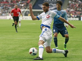 Ignacio Piatti of the Montreal Impact dribbles past Christian Bolanos (7) of the Vancouver Whitecaps during their MLS game March 6, 2016, at BC Place in Vancouver.