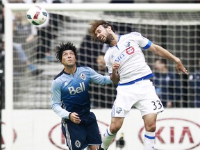 Impact's Marco Donadel heads ball as Christian Bolanos of the Vancouver Whitecaps looks on during their MLS game March 6, 2016, at BC Place in Vancouver.