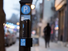 A parking spot marker stands next to a payment station on Wellington St.