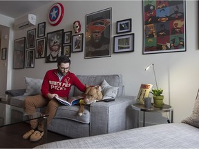 Adam Bruno and his dog, Boss, in the living room which features a wall filled with drawings of comic book superheroes in his condo in Montreal on Wednesday February 10, 2016. (Pierre Obendrauf / MONTREAL GAZETTE)
