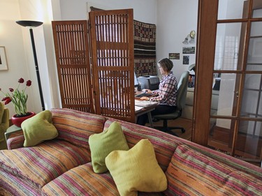 Sarah Dougherty works in her home office which adjoins the living room of her apartment. (John Mahoney / MONTREAL GAZETTE)