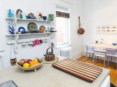 Shelves with pottery and a fly-fishing basket are on display on a kitchen wall. (John Mahoney / MONTREAL GAZETTE)