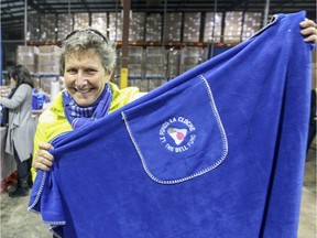 Judy Martin holds up one of the blankets going into comfort kits being assembled by volunteers at the Simard Warehouse in Lachine.
