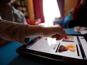 A child with autism uses an iPad application called Proloquo2go, a communication tool for people with developmental disorders, to ask for food at his home in Montreal on Monday, February 21, 2011.