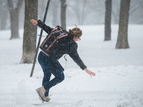 MONTREAL, QUE.: FEBRUARY 24, 2016 -- A woman slips on a patch of ice on a sidewalk through Jeanne-Mance park during a moderate snow fall in Montreal on Wednesday, February 24, 2016. Snow gave way to freezing rain and then rain by the afternoon. (Dario Ayala / Montreal Gazette)