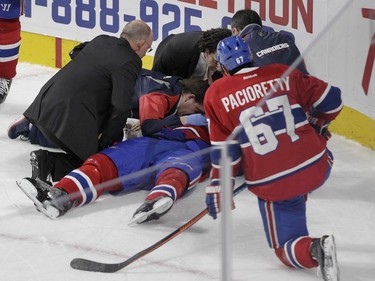 Captain Max Pacioretty watches as P.K. Subban of the Montreal Canadiens is tended to by the team's medical staff after sustaining an injury against the Buffalo Sabres in the third period of an NHL game at the Bell Centre in Montreal Thursday, March 10, 2016.