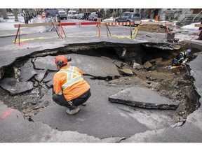 Worker in sinkhole that opened up at the corner of Laval St. and Square Saint-Louis on Thursday.