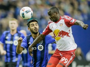 Montreal Impact defender Victor Cabrera, left, battles for the ball against New York Red Bulls forward Bradley Wright-Phillips, right, during the first half of the Impact's home opening match at the Olympic Stadium in Montreal on Saturday, March 12, 2016.