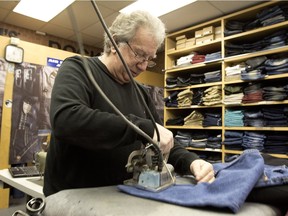 Owen Stroll irons a freshly sewn hem on a pair of jeans at Pantalons Supérieur in downtown Montreal.