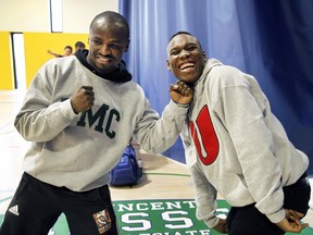 Boxers Yves Junior Ulysse, right, and Dierry Jean, strike a pose during a photo session after the inauguration of a new gymnasium at Vincent Massey Collegiate in Montreal on Friday March 18, 2016.