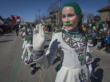 Twelve-year-old Alicia Marsh waves to the crowds at the St. Patrick's Parade in Hudson on Saturday, March 19, 2016.