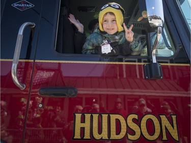 Ethan Sodo smiles from one of Hudson's fire trucks during the St. Patrick's Parade on Saturday, March 19, 2016.