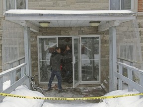 Police arson investigators survey the scene at an apartment building at 2985 Bedford St. in Côte-des-Neiges, Montreal, Wednesday March 2, 2016, after a suspicious fire. Three people were taken to hospital with non life-threatening injuries, according to police.