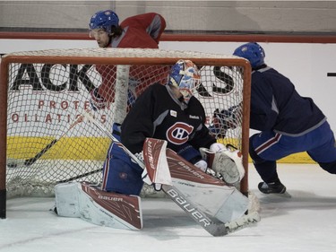 Canadiens centre David Desharnais ducks behind Montreal Canadiens goalie Mike Condon's net as Joel Hanley chases him during a team practice at the Bell Sports Complex in Montreal on Friday March 25, 2016.