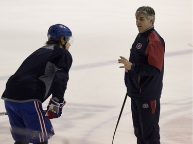 Canadiens goalie Ben Scrivens tosses a puck around as assistant coach Jean-Jacques Daigneault speaks with Canadiens defensceman Nathan Beaulieu during a team practice at the Bell Sports Complex in Montreal on Friday March 25, 2016.