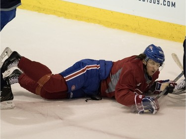 Canadiens' Sven Andrighetto grimaces as he hits the ice after being checked during a team practice at the Bell Sports Complex in Montreal on Friday March 25, 2016.