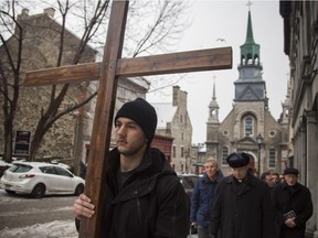 Worshipers walk up Bonsecours St. as they participate in the Way of the Cross procession through the streets of Montreal on Friday March 25, 2016.