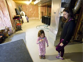 Magalie Seabrooke and her daughter Avery Stevenson, 4, in the stripped-down basement of their home in Vaudreuil-Dorion on Monday, March 28, 2016.  The family has been having severe mould issues in the house due to high humidity, and they have been having trouble getting help to solve this issue.  (Phil Carpenter / MONTREAL GAZETTE)