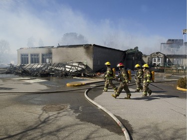 Firefighters battle a blaze at Ste-Julienne city hall north of Montreal March 29, 2016. The building is a total loss even though the fire station is next door.
