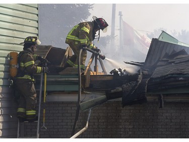 Firefighters battle a blaze at Ste-Julienne city hall north of Montreal March 29, 2016. The building is a total loss even though the fire station is next door.