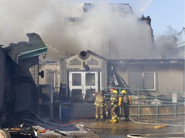 Firefighters battle a blaze at Ste-Julienne city hall north of Montreal March 29, 2016. The building is a total loss even though the fire station is next door.