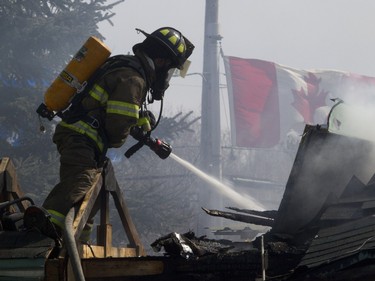 Firefighters battle a blaze at the Ste-Julienne city hall, north of Montreal, March 29, 2016.