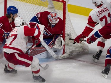 MONTREAL, QUE.: MARCH 29, 2016-- Montreal Canadiens goalie Mike Condon makes a save as Detroit Red Wings defenseman Kyle Quincey and Detroit Red Wings center Dylan Larkin look for a rebound during NHL action at the Bell Centre in Montreal on Tuesday March 29, 2016. (Allen McInnis / MONTREAL GAZETTE)