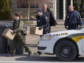 Sûreté du Québec, RCMP and Canada Border Services agents carry boxes from a house in Sainte-Marthe-sur-le-Lac, north of Montreal, March 30, 2016, as part of an operation against tobacco smuggling.