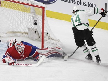 Goalie Ben Scrivens of the Montreal Canadiens stretches to stop Jamie Benn of the Dallas Stars in the first period of an NHL game at the Bell Centre in Montreal Tuesday, March 8, 2016.