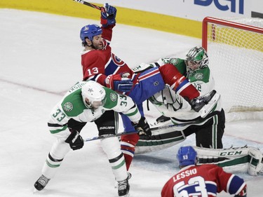 Mike Brown of the Montreal Canadiens tries to keep his balance in front of the net of the Dallas Stars while under pressure from defenceman Alex Goligoski and goalie Kari Lehtonen in the second period of an NHL game at the Bell Centre in Montreal Tuesday, March 8, 2016.