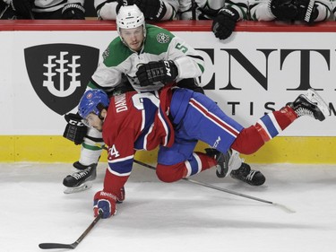Phillip Danault of the Montreal Canadiens is knocked over by Jamie Oleksiak of the Dallas Stars in the first period of an NHL game at the Bell Centre in Montreal Tuesday, March 8, 2016.
