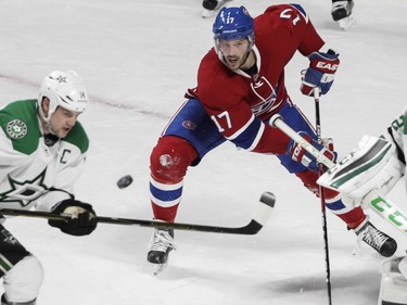 Torrey Mitchell of the Montreal Canadiens and Jamie Benn of the Dallas Stars keep their eyes on a flying puck in the second period of an NHL game at the Bell Centre in Montreal Tuesday, March 8, 2016.
