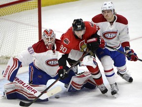 Ottawa Senators' Alex Chiasson (90) tries to get a piece of the puck as it's shot towards Montreal Canadiens' goalie Ben Scrivens (40) and Nathan Beaulieu (28) during first period NHL hockey action in Ottawa on Saturday, March 19, 2016.