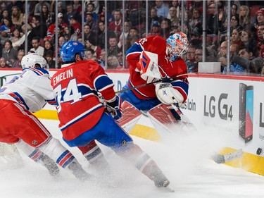 Goaltender Mike Condon of the Montreal Canadiens tries to clear the puck against the boards during the NHL game against the New York Rangers at the Bell Centre on March 26, 2016, in Montreal.